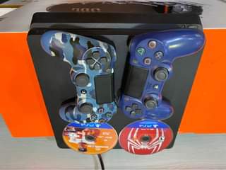 A picture of Sony PlayStation 4 slim 512gb with 2game controllers 2 cds