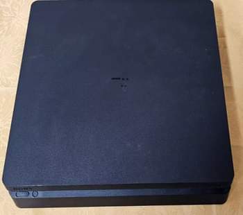A picture of playstation 4 slim with 10 games 2 controller power cable