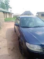 A picture of Mazda 323f Manual drive New baked on first body Tokunbo