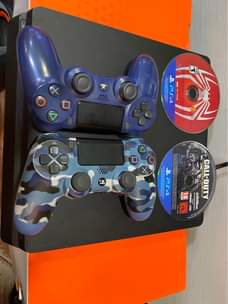 A picture of Sony PlayStation 4 slim with 2 game controllers and 2