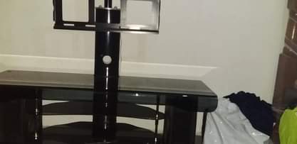 A picture of Tv glass table with hoofer