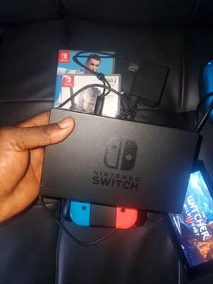 A picture of Nintendo Switch with all original accessories plus games