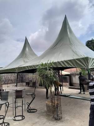 A picture of 100seater tent green top cover with its back flap