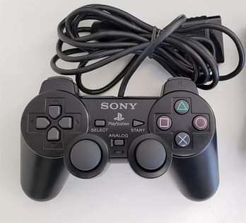 A picture of playstation 2 with 2 controllers and cables plus 10 games
