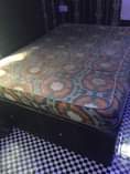 A picture of 6 by 4 feet bed and bedframe and standing fan