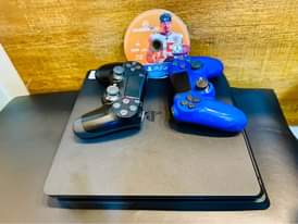 A picture of Sony PlayStation 4 slim with 2 game controllers and 1