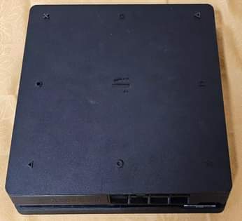 A picture of playstation 4 slim with 10 games 2 controller power cable