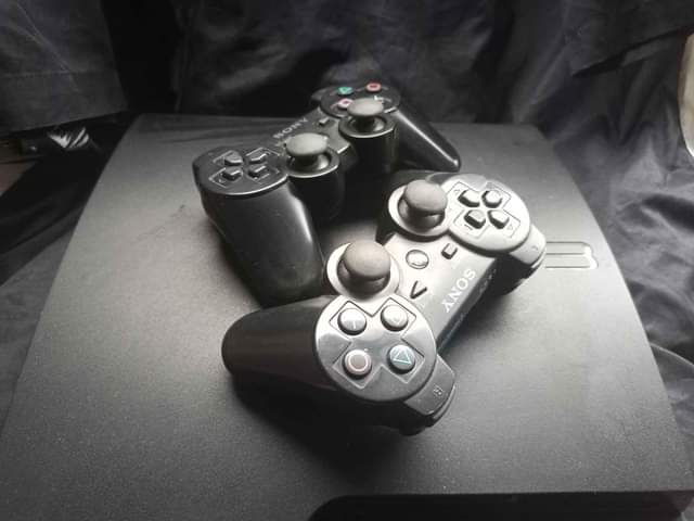 A picture of Ps3 with two follow come pad