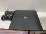 A picture of Sony PlayStation 4 pro with fifa 2022 and 2game controllers