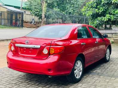 A picture of Pepper red 2010 Corolla Le available Abuja used owner 7m