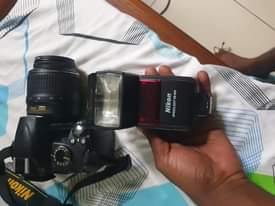 A picture of Nikon D3000 lens 18 55mm and speed light
