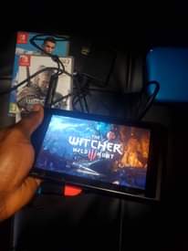 A picture of Nintendo Switch with all original accessories plus games