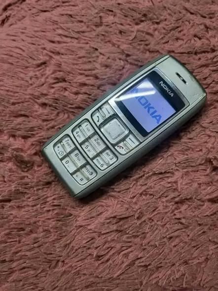 A picture of NOKIA 1600 GLASS BUTTON PHONE WITH AN ORIGINAL NOKIA HANDSHAKE