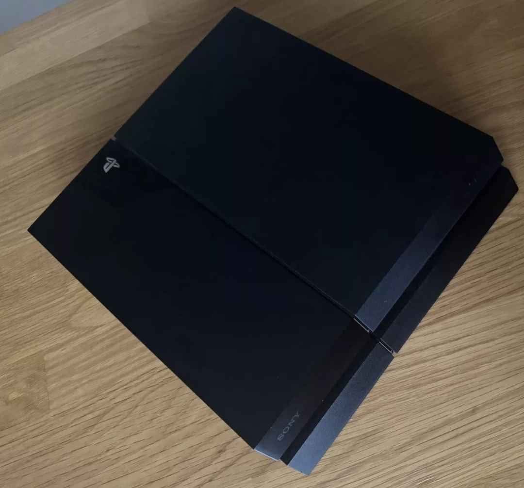A picture of Ps4 standard with 2 controllers and 4 games installed