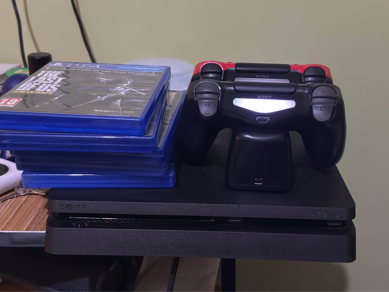 A picture of PS4 slim with 5 CD games and 10 games downloaded