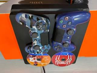 A picture of Sony PlayStation 4 slim 512gb with 2game controllers 2 cds