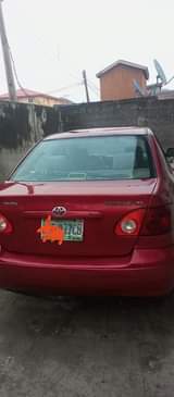 A picture of Corolla 2003 painted red registered with smoking engine and other