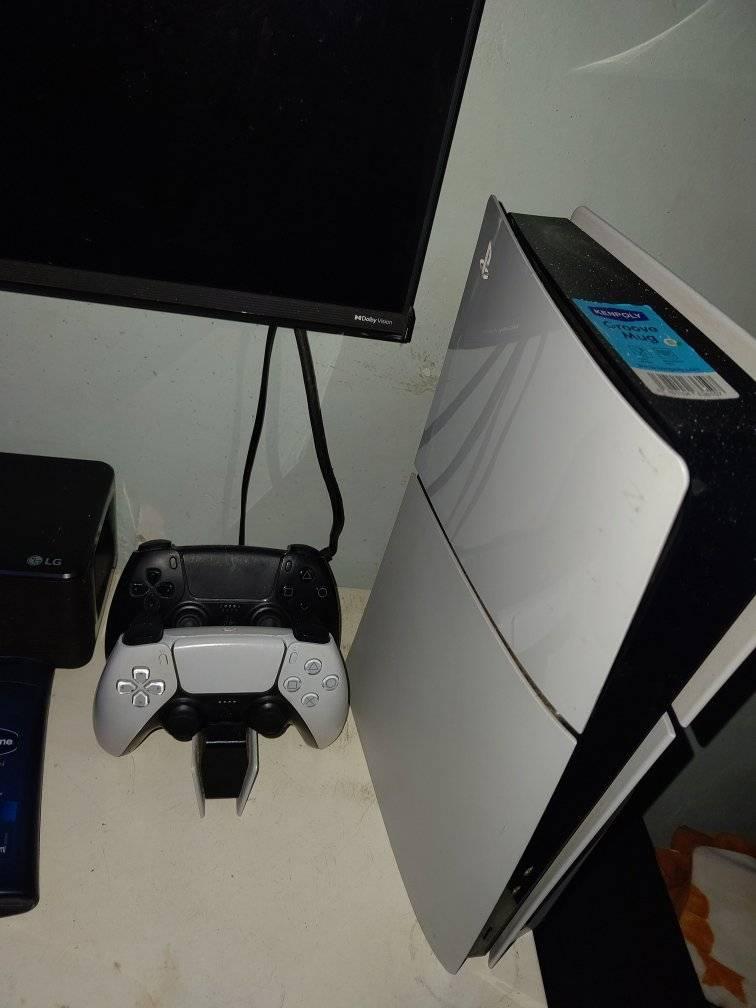 A picture of Play station five with two controllers and five games