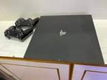 A picture of Sony PlayStation 4 pro with fifa 2022 and 2game controllers