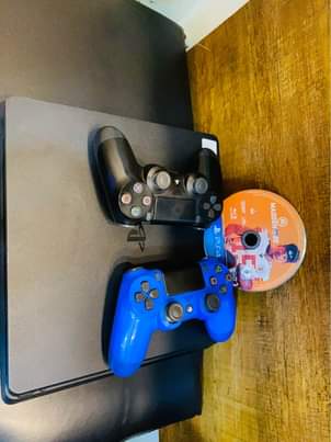 A picture of Sony PlayStation 4 slim with 2 game controllers and 1