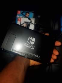 A picture of Nintendo Switch with all original accessories plus games