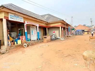 A picture of 5 shops with 4 single rooms behind for sale in